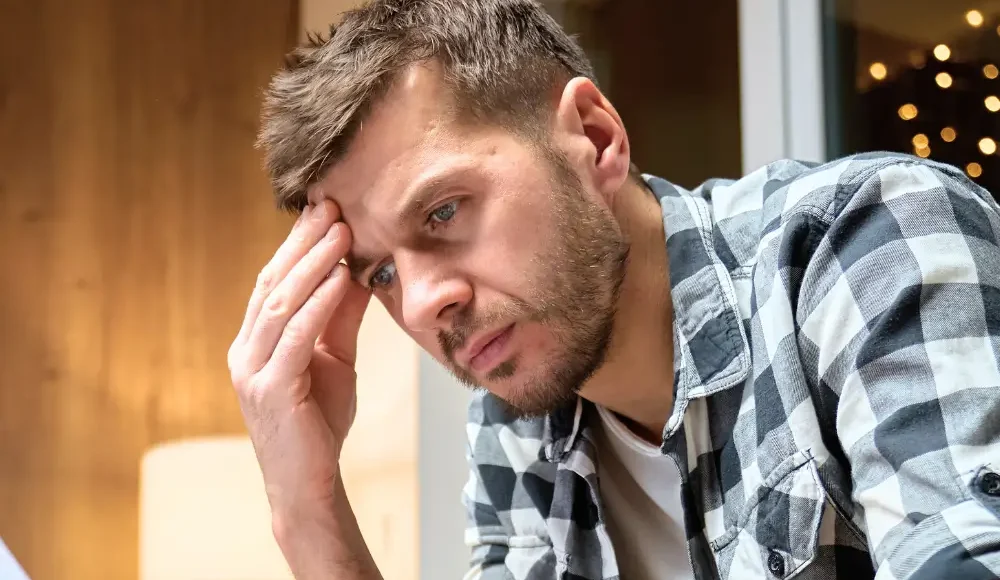 Worried homeowner in 33009 reviewing bills and foreclosure-related paperwork at home